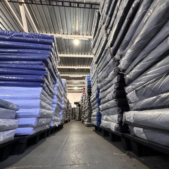 Culoar cu baloturi de material tricot in depozitul Suntex