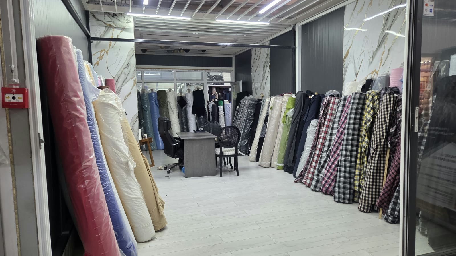 Interiorul standului Suntex: role de tricot si materiale in carouri